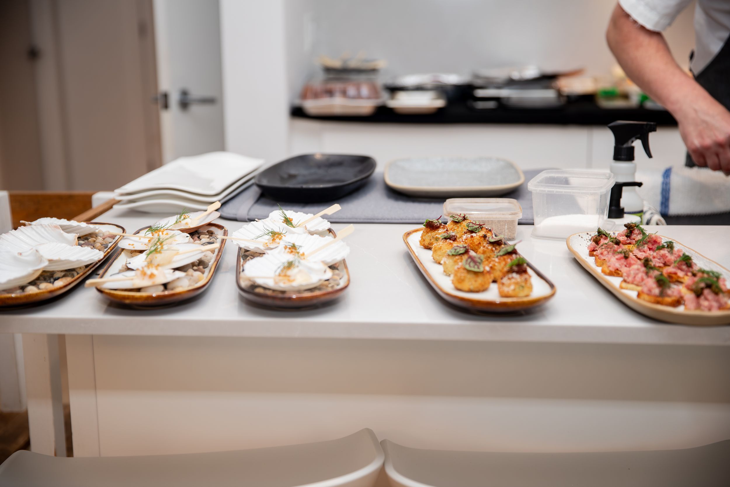Close-up view of plates with various dishes being prepared in a professional kitchen setting.