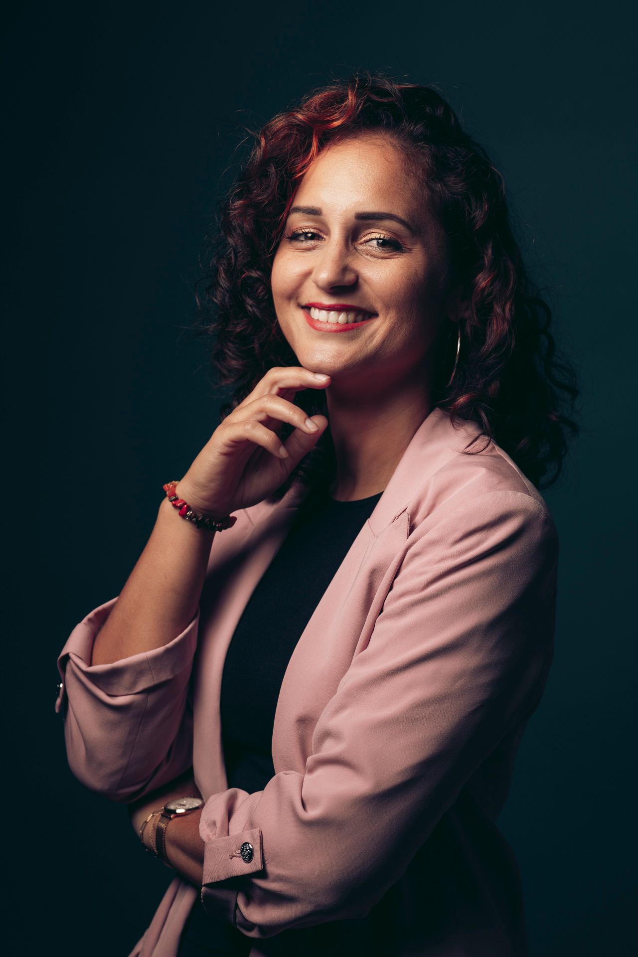 Professional headshot of a person in a white dress shirt against a textured backdrop.