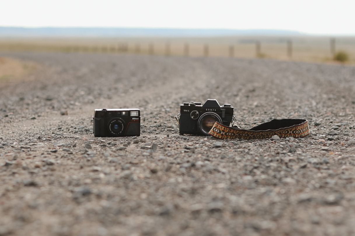 Camera equipment lying on textured concrete ground surface.