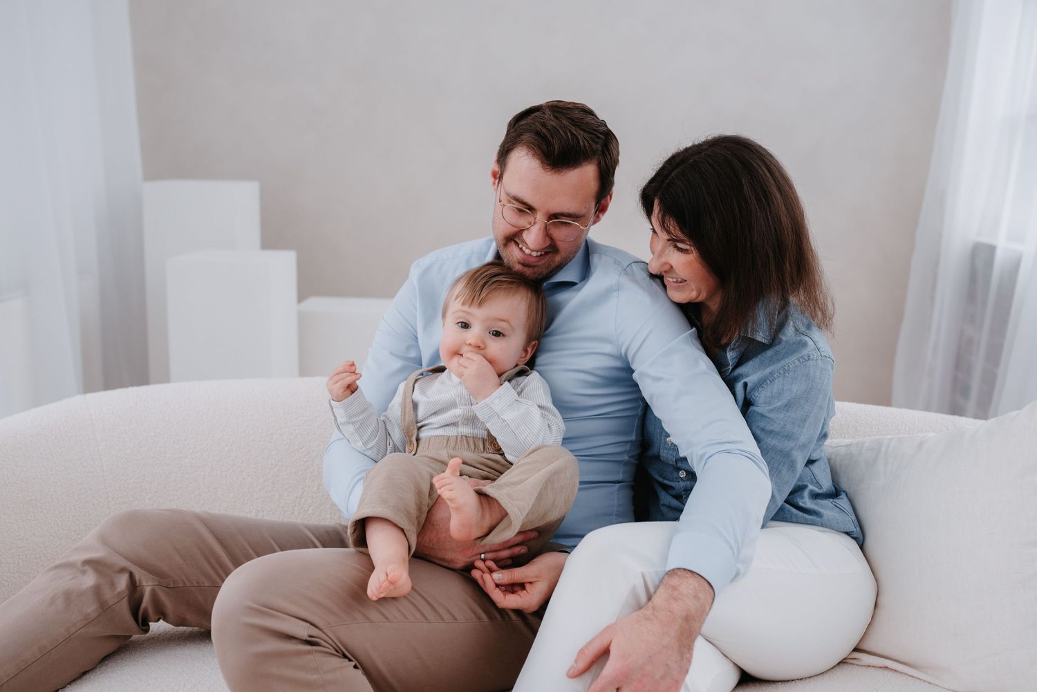 Intimate family portrait session in a bright minimalist setting showing tender moments.