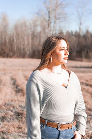 Outdoor portrait in winter landscape with person wearing gray sweater.