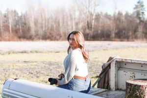 Outdoor photoshoot scene with vintage truck and natural lighting.