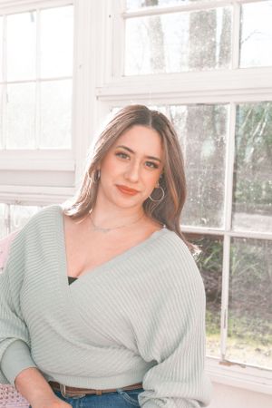 Portrait in soft lighting showcasing casual sweater and denim style.