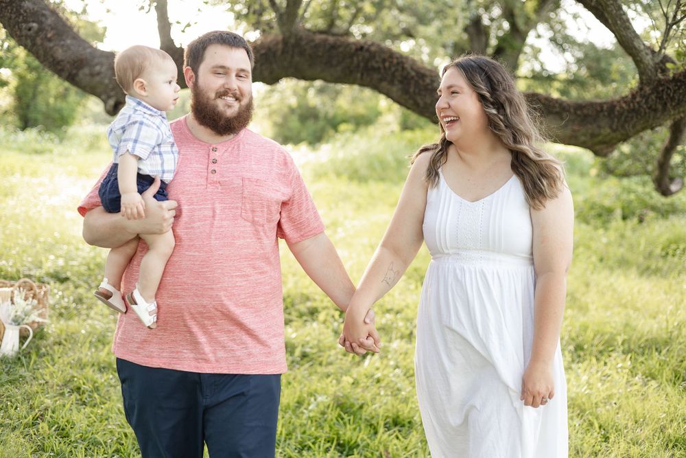 A family enjoys a playful moment together outdoors in coordinated casual attire.