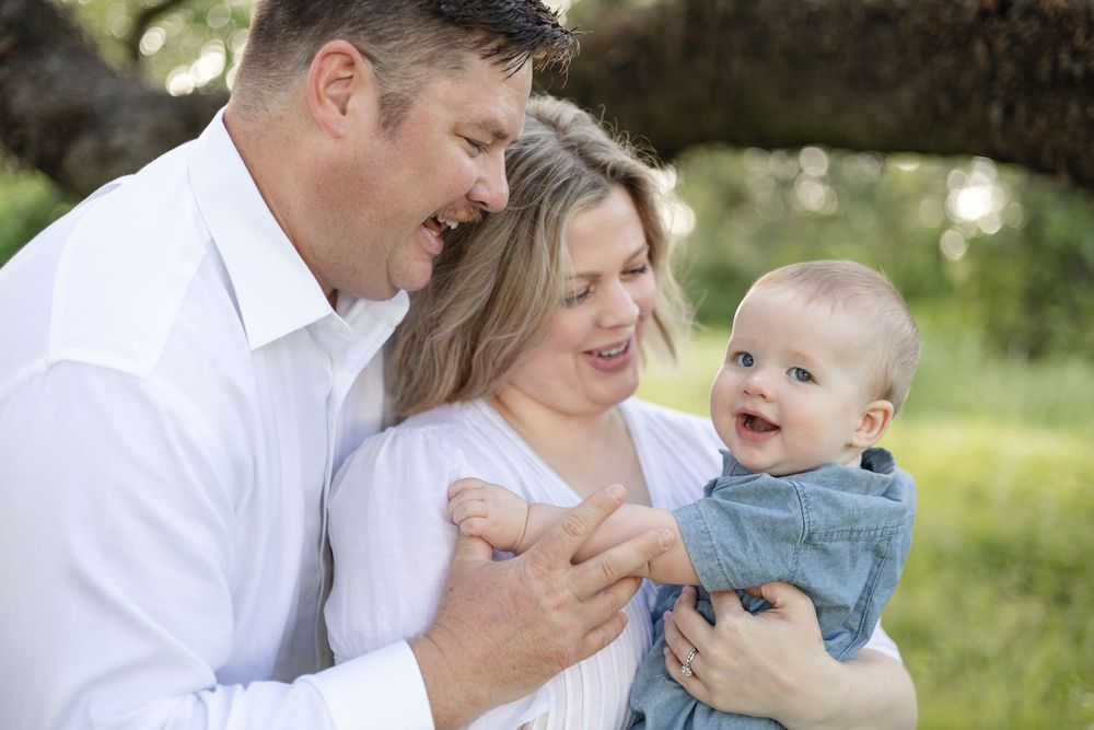 An intimate family portrait session outdoors with a baby in denim clothing.