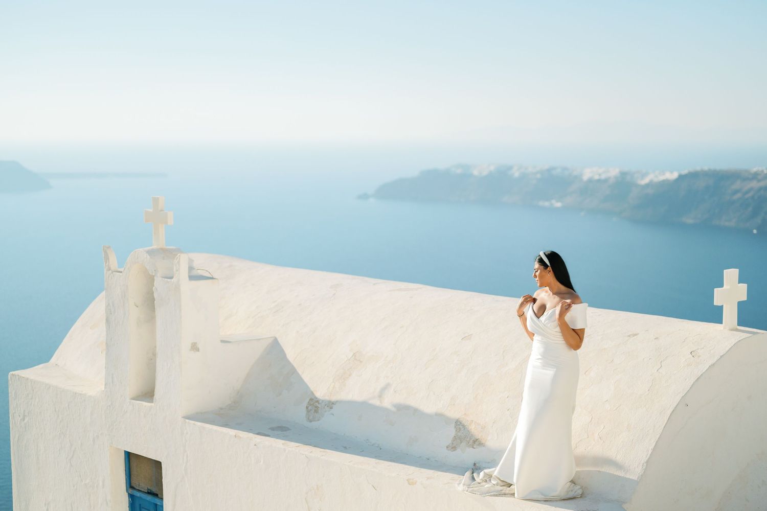On a whitewashed terrace overlooking the Aegean, the bride's veil dances in the breeze.