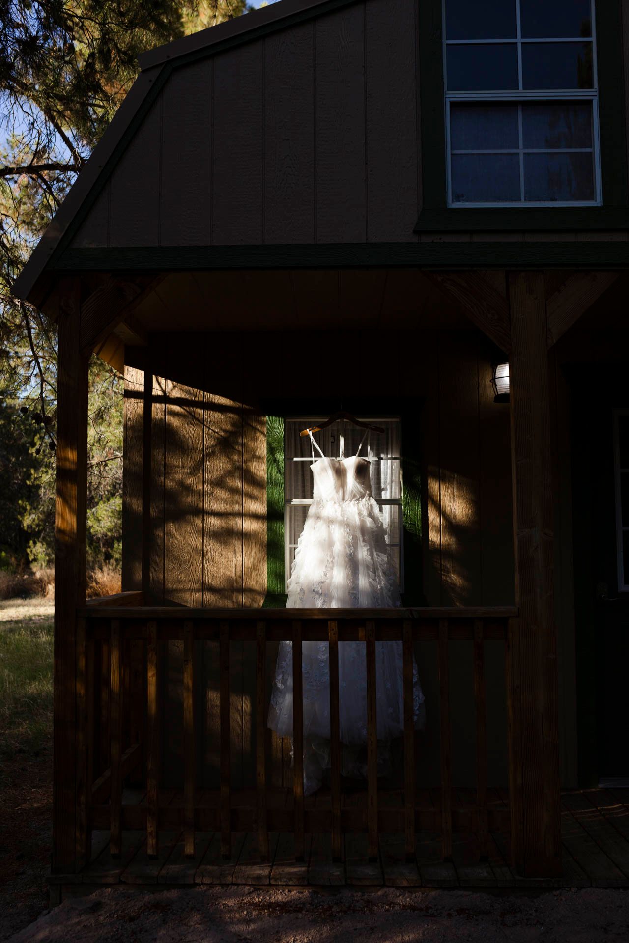 Sustainable wedding day tips link. Bridal Gown hanging in a cabin window.