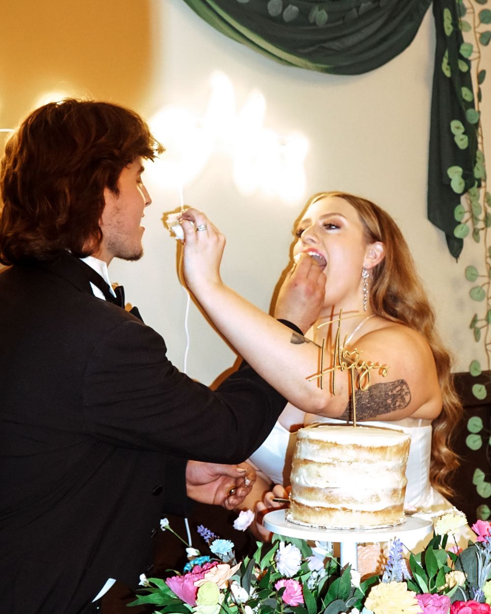 Bride and groom celebrating their love in Southeast Georgia during a cake cut, surrounded by elegant golden light