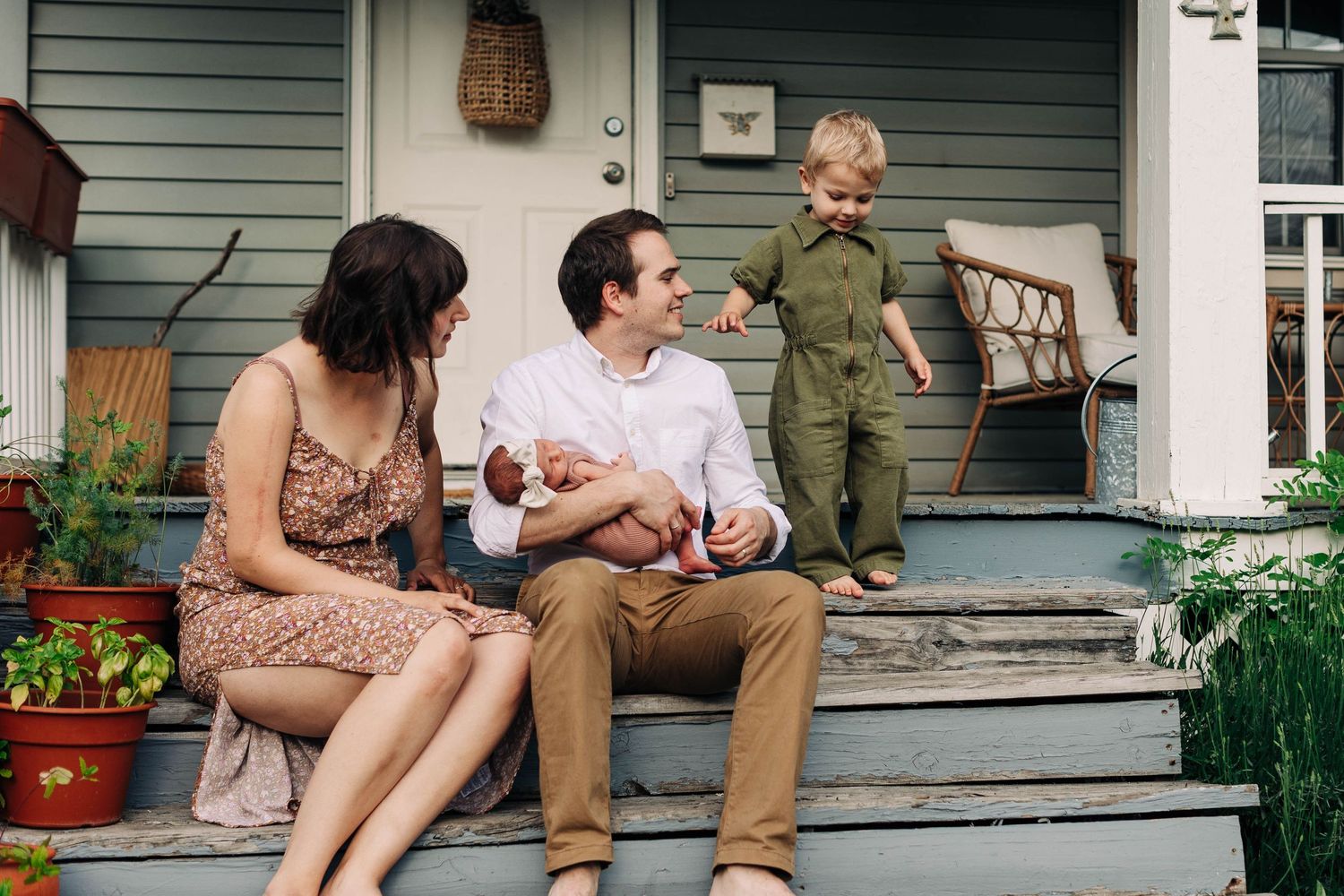 Family having tender moment together on front porch steps of their home.