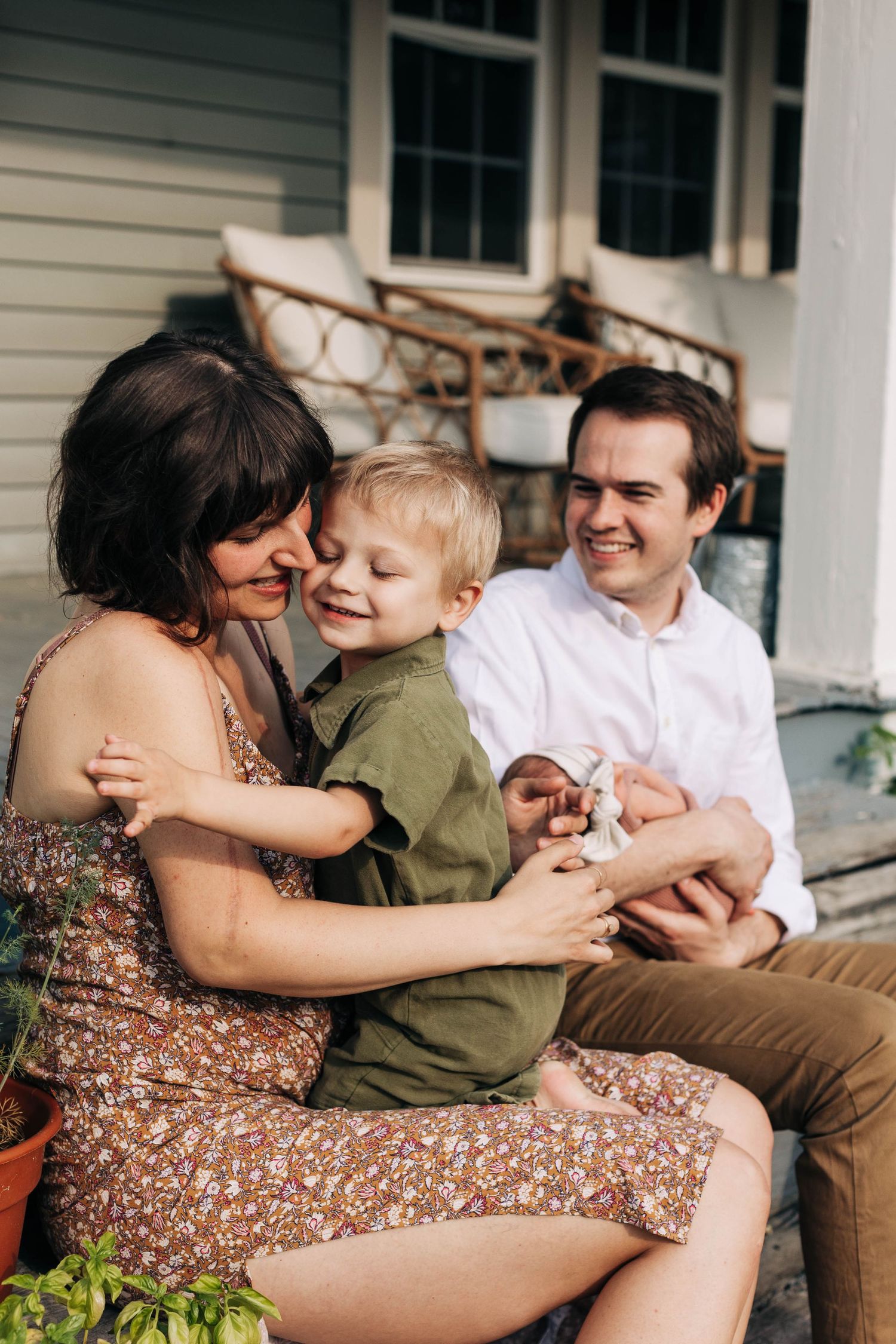Intimate family moment captured on front porch during lifestyle photoshoot.