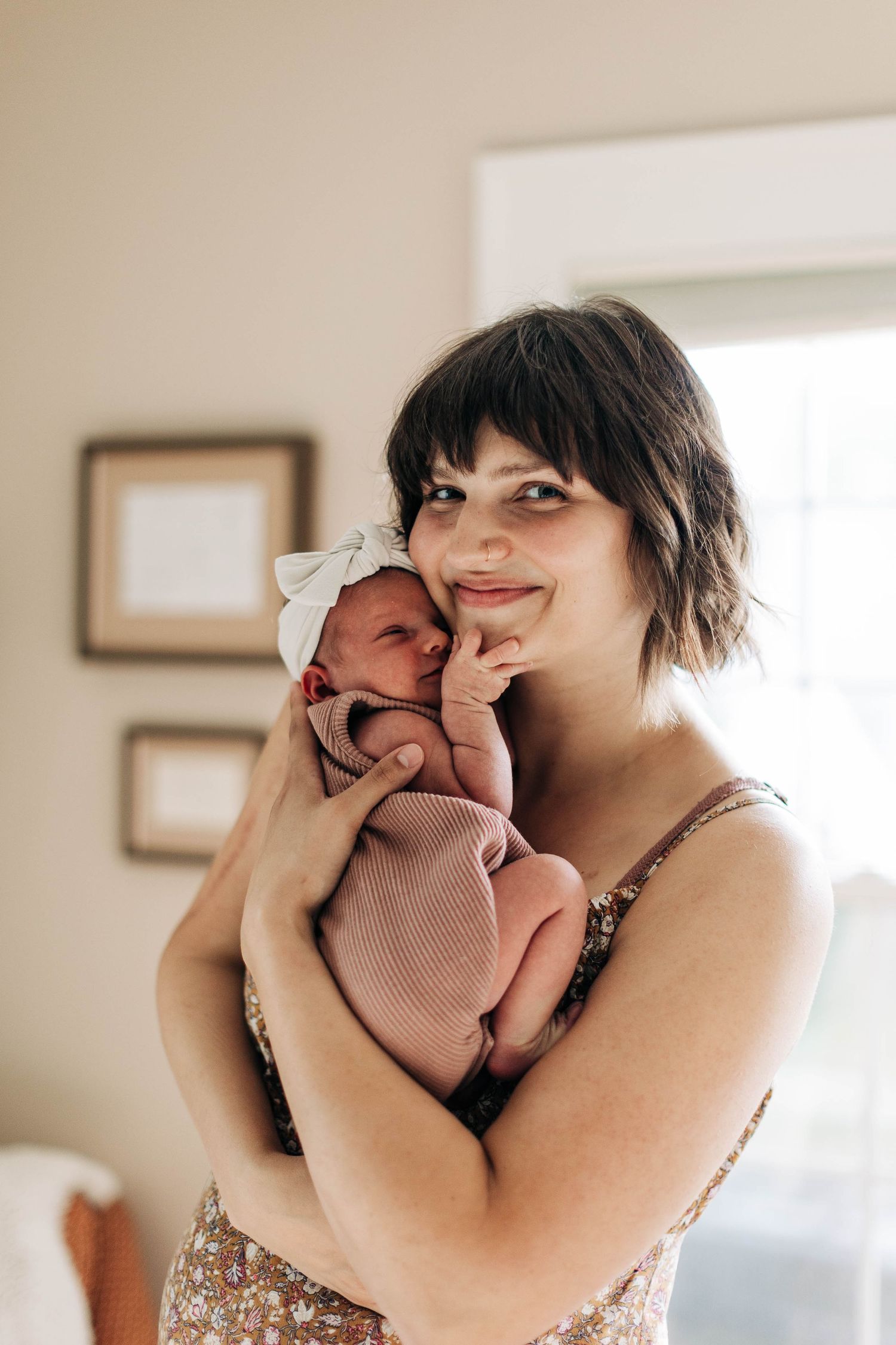 Intimate indoor portrait in a bright minimalist room with natural lighting.