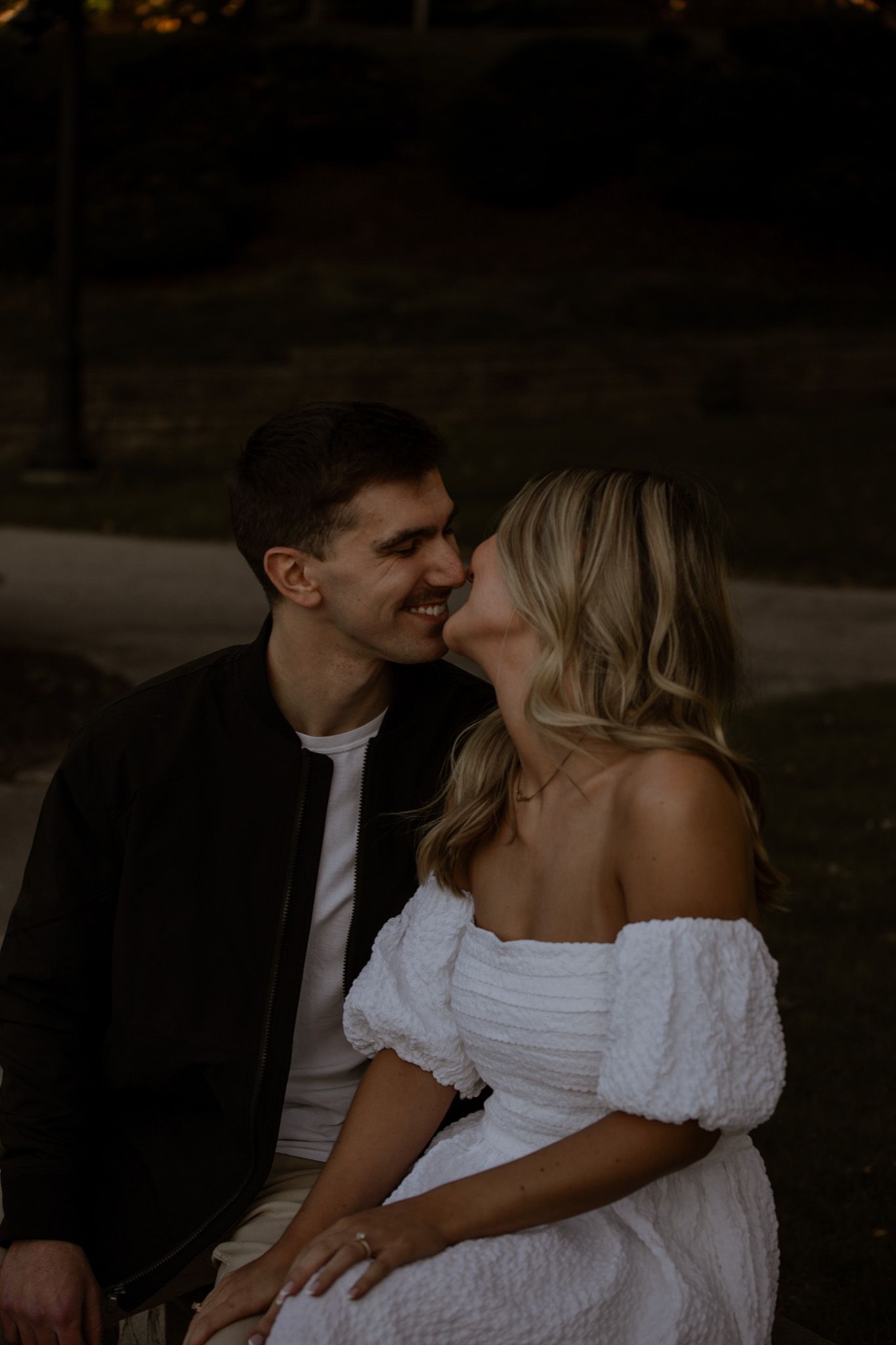 Romantic evening moment between couple with one wearing white dress.