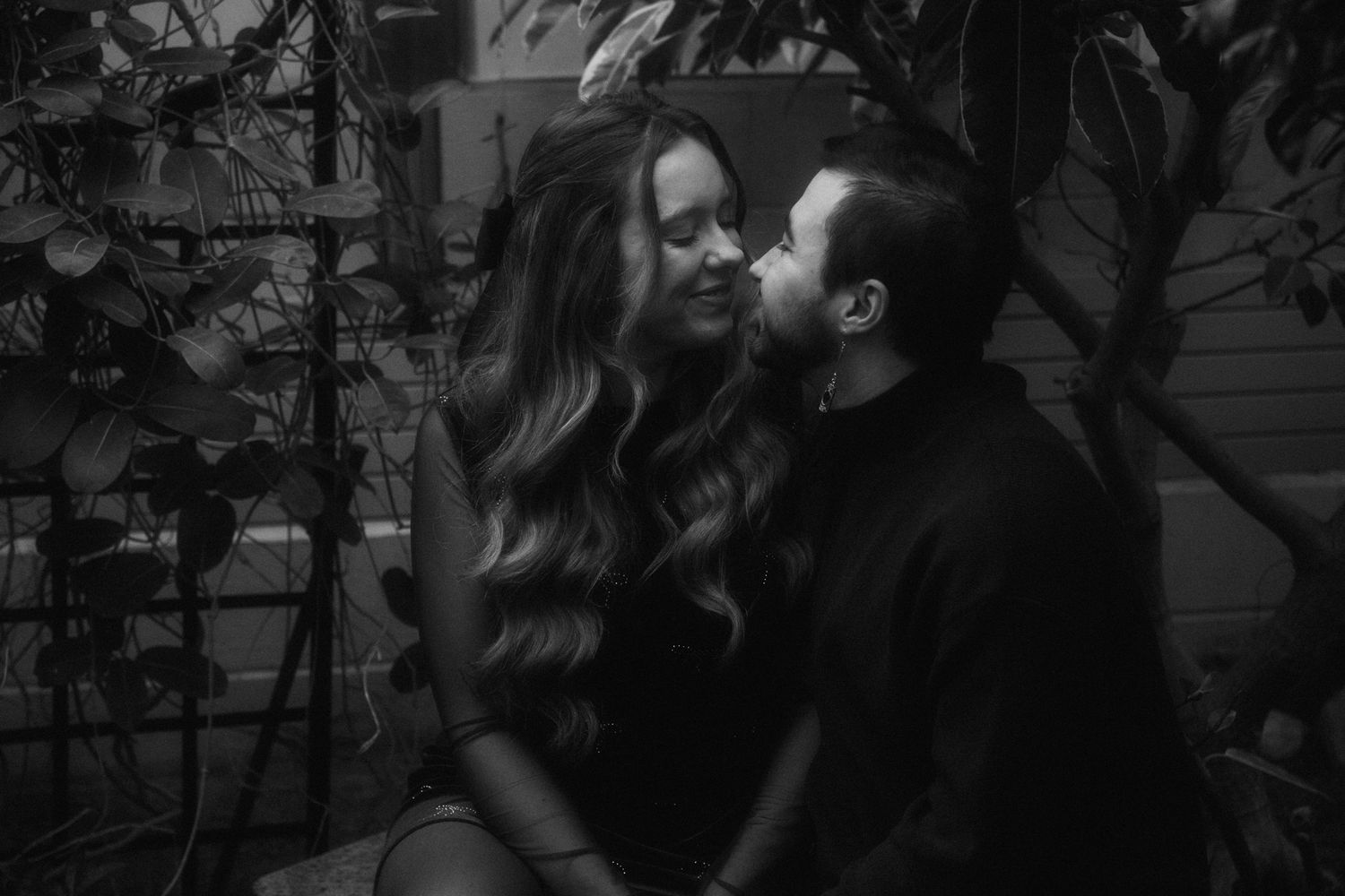An intimate black and white portrait of a couple sharing a romantic moment.