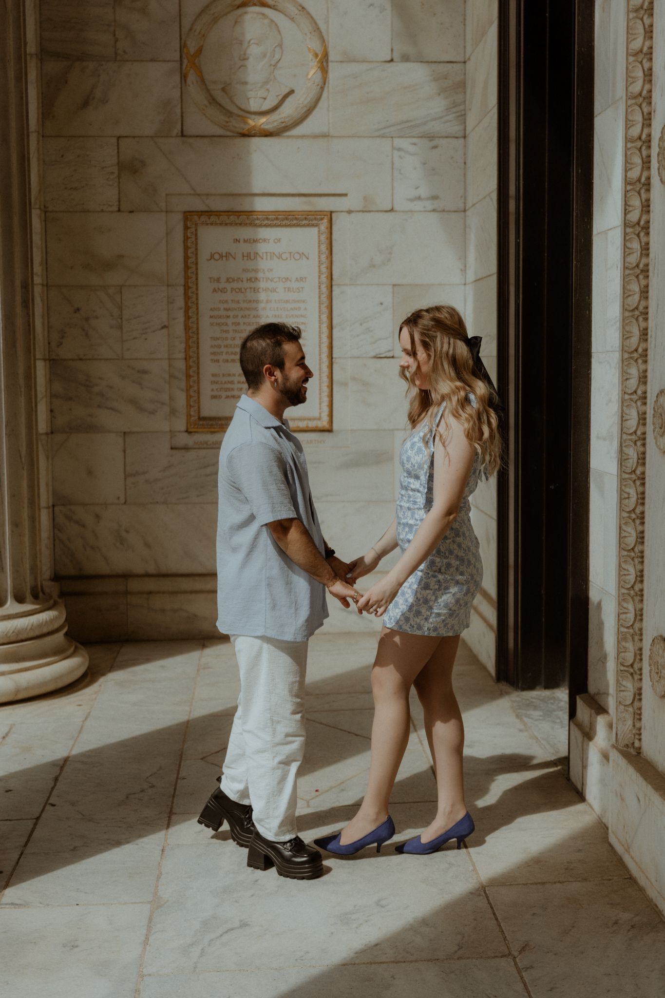 A surprise proposal moment captured in an elegant marble hallway.