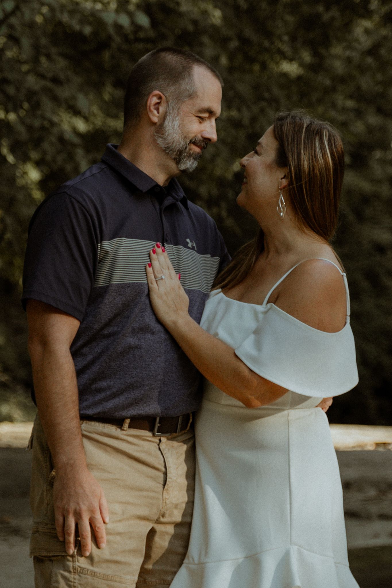 A couple embraces tenderly in a natural outdoor setting.