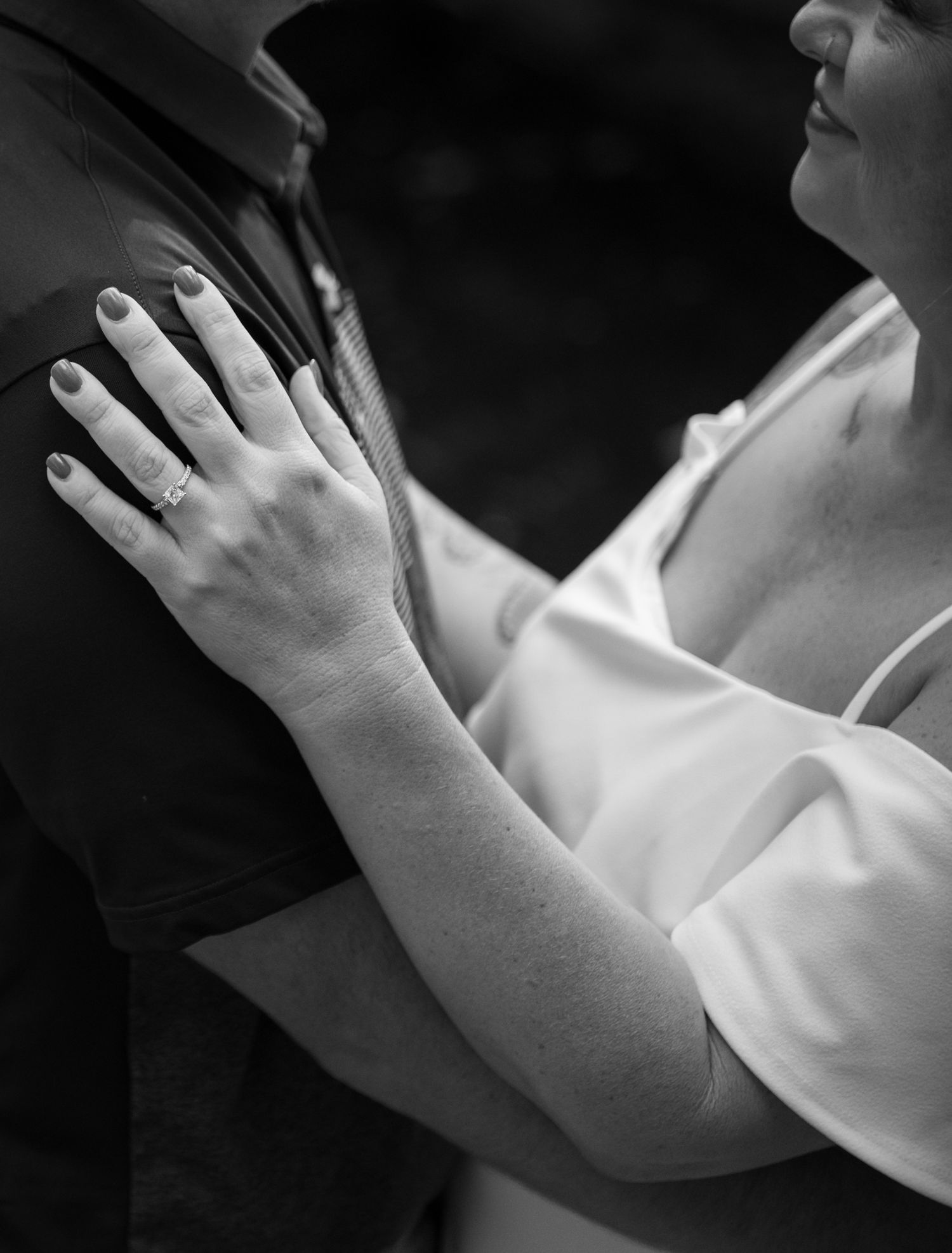 Close-up of hands resting gently against white fabric.