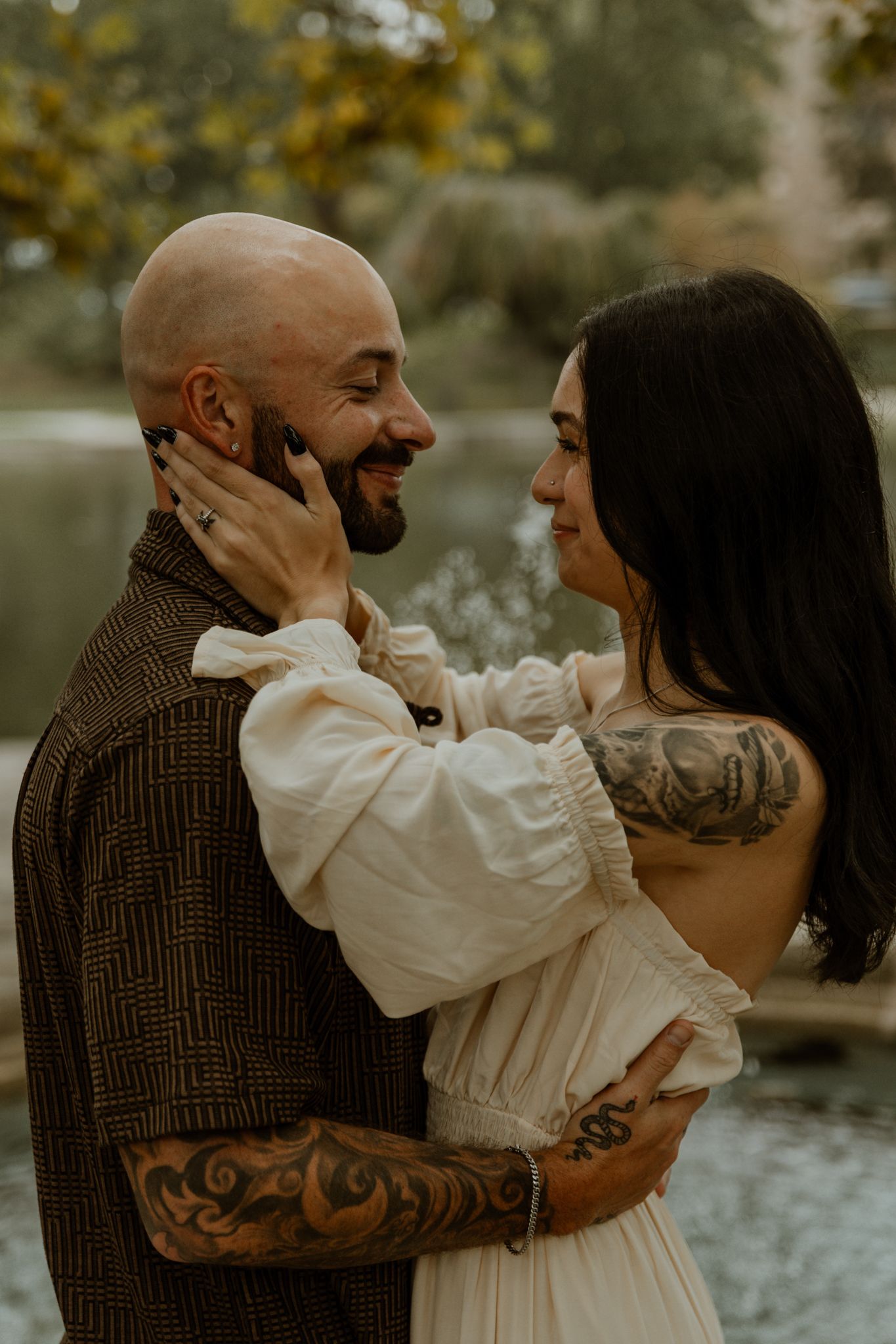 Couple in vintage clothing sharing romantic moments by a lake.