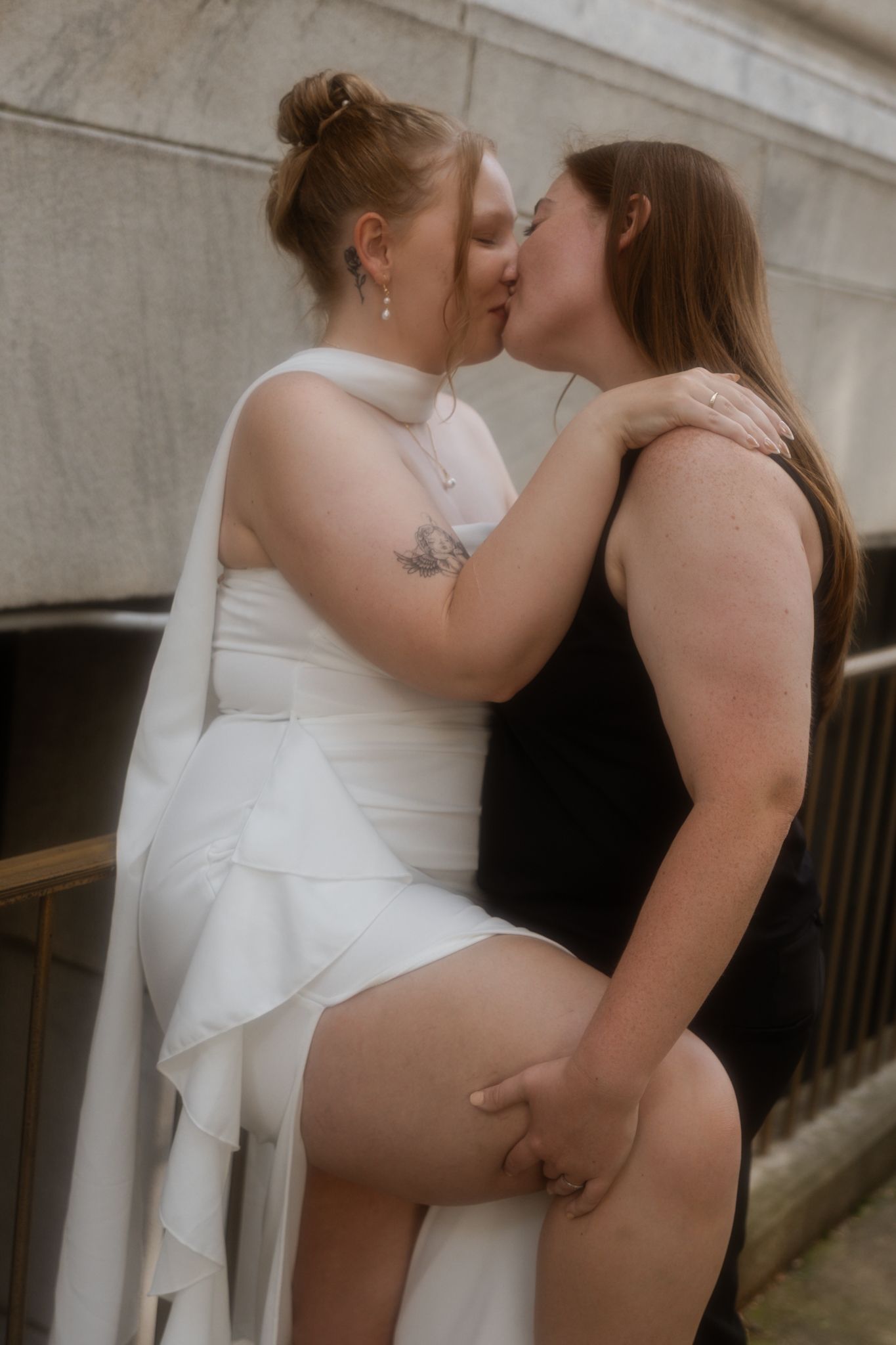 Two people in intimate embrace wearing white and black outfits.