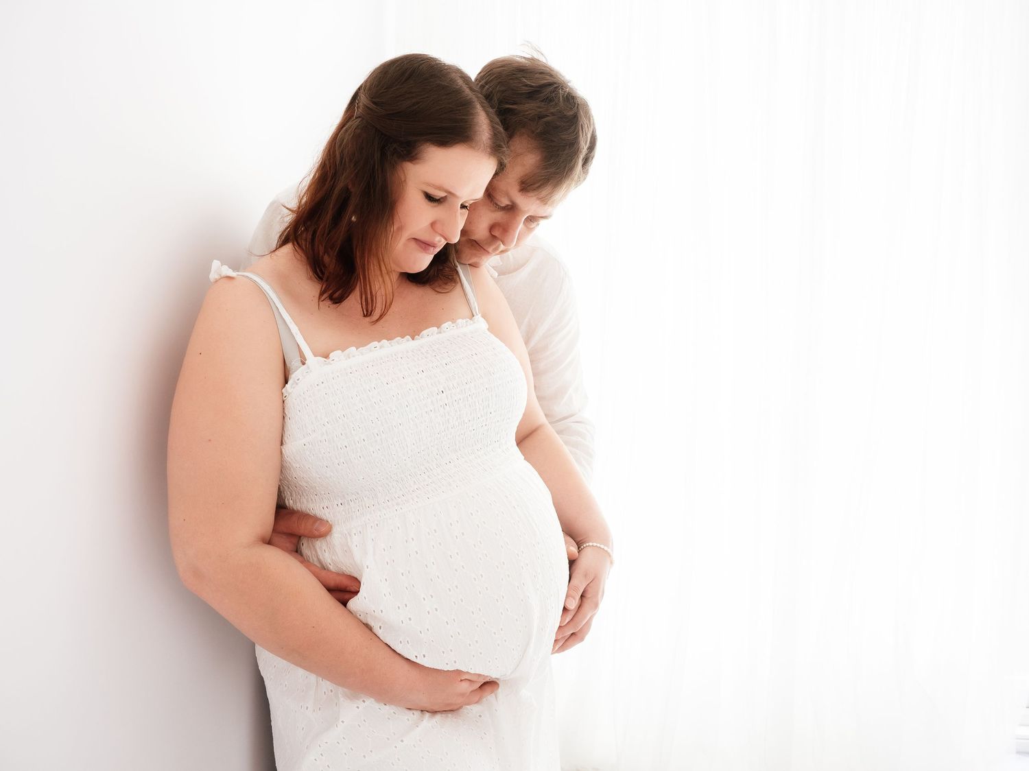 a young pregnant woman and her partner pose for photographs during a session with Verity Photography