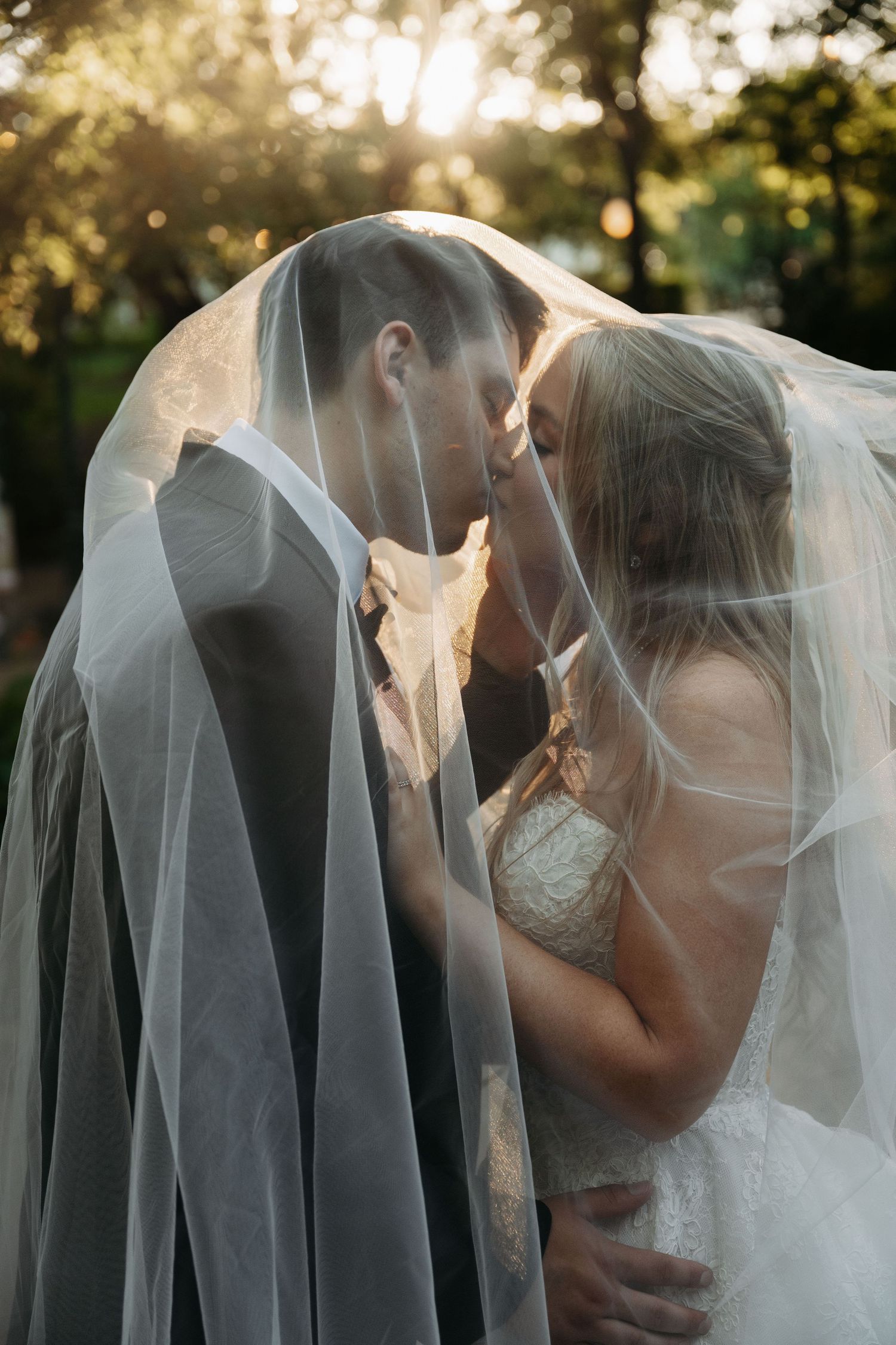Couple shares playful moments together under outdoor string lights at dusk.