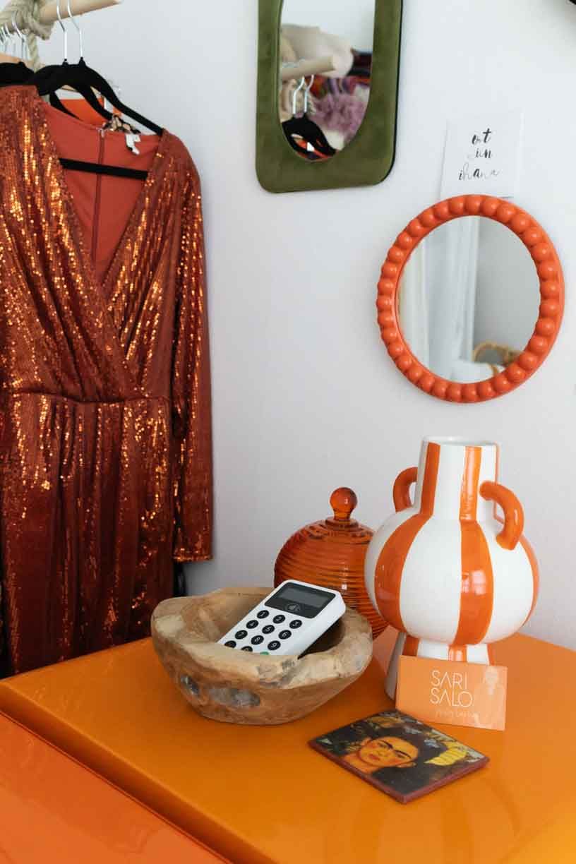 A sequence of four photos showing a sparkly orange dress hanging near an orange circular mirror and decor items.