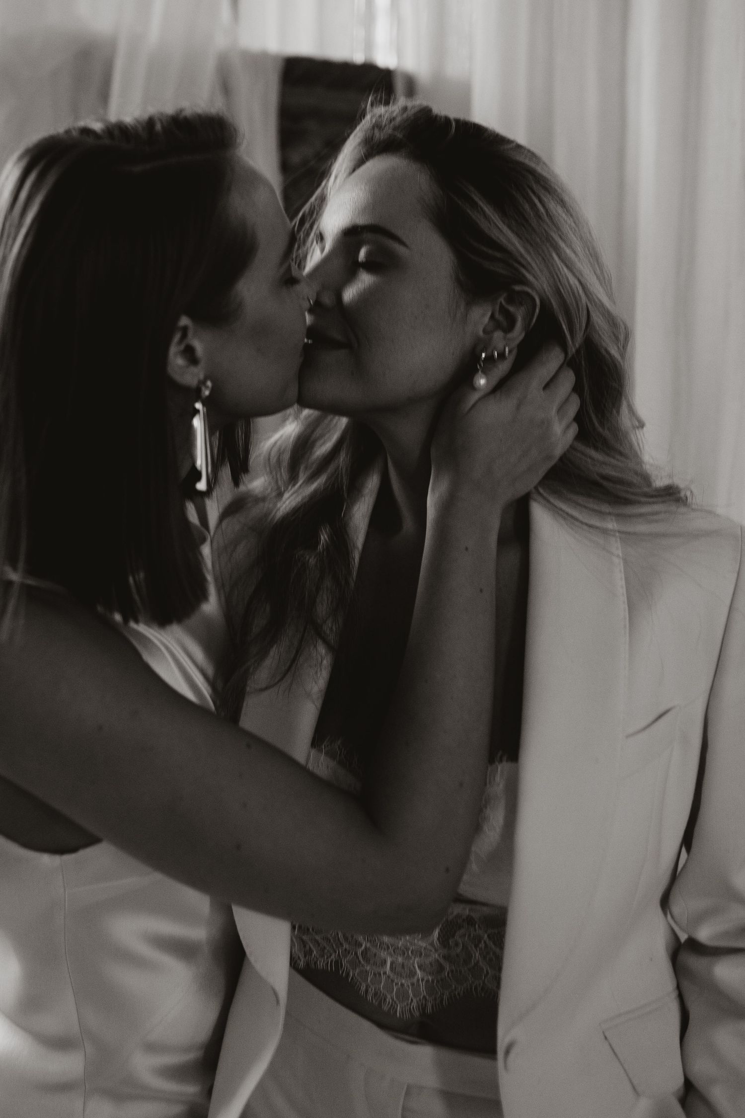Intimate black and white portrait of two people in white suits.