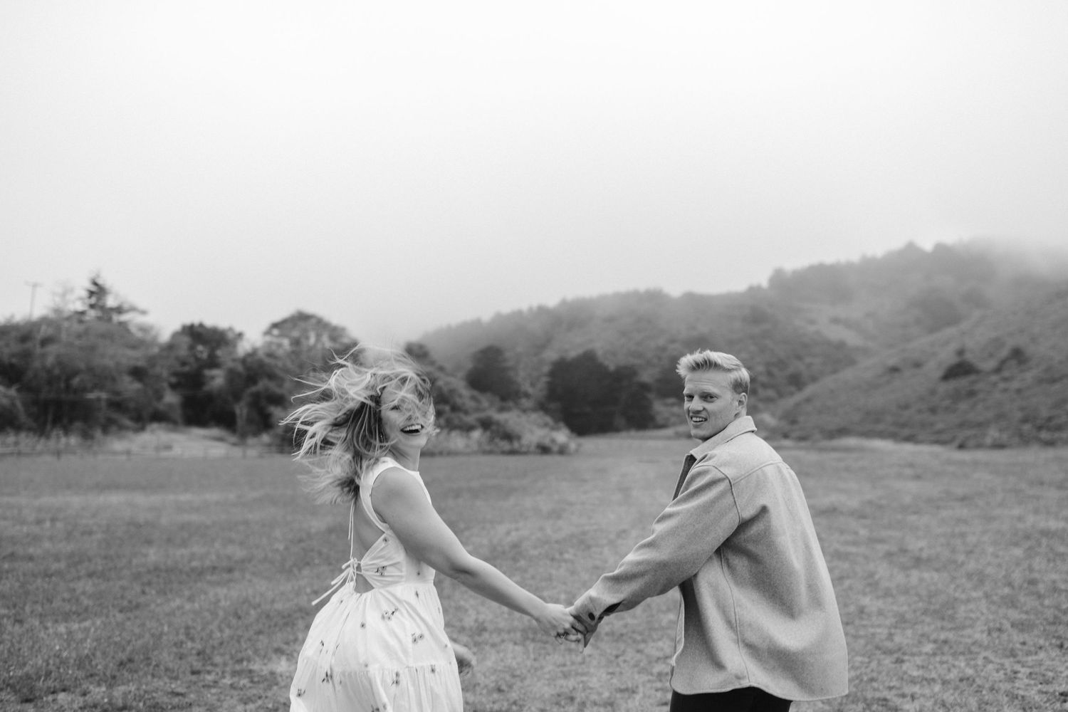 Black and white photo of couple dancing in open field.