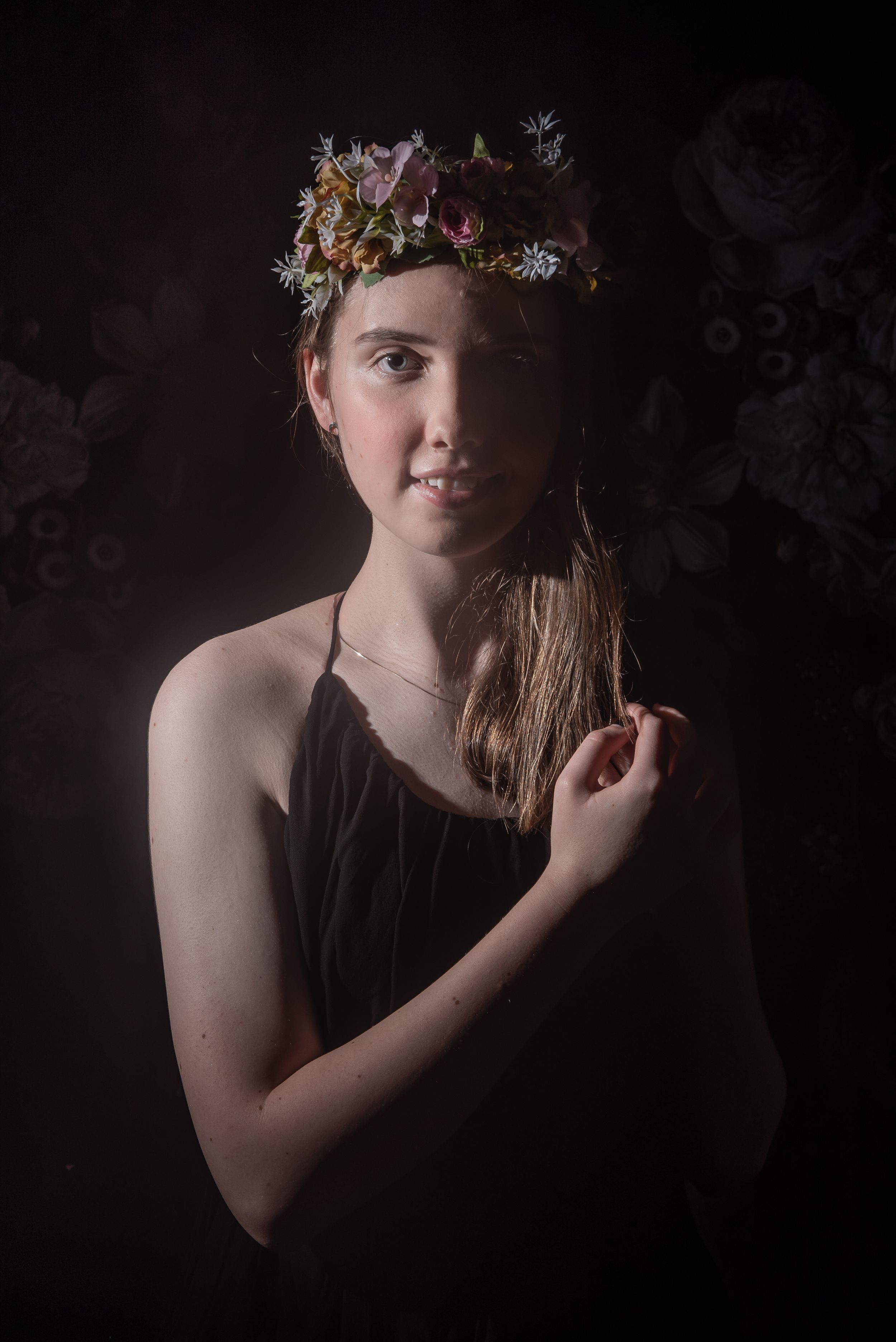 A series of moody portrait photographs showing someone wearing a floral crown against a dark background.