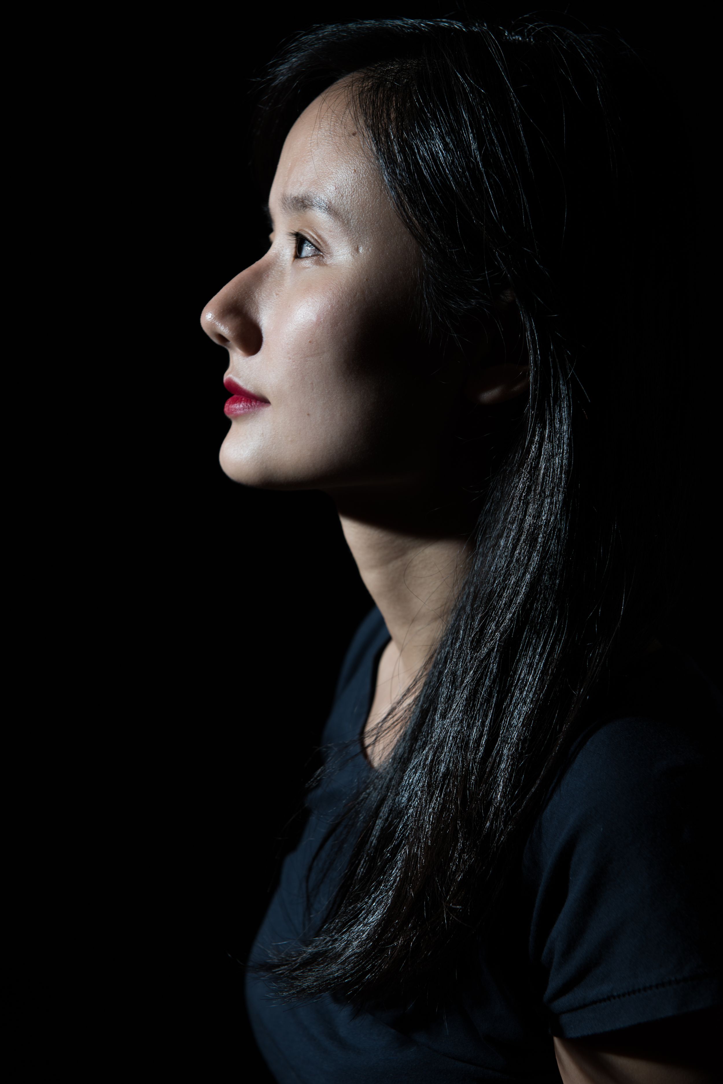 Side profile silhouette of a woman with dark hair against black background.