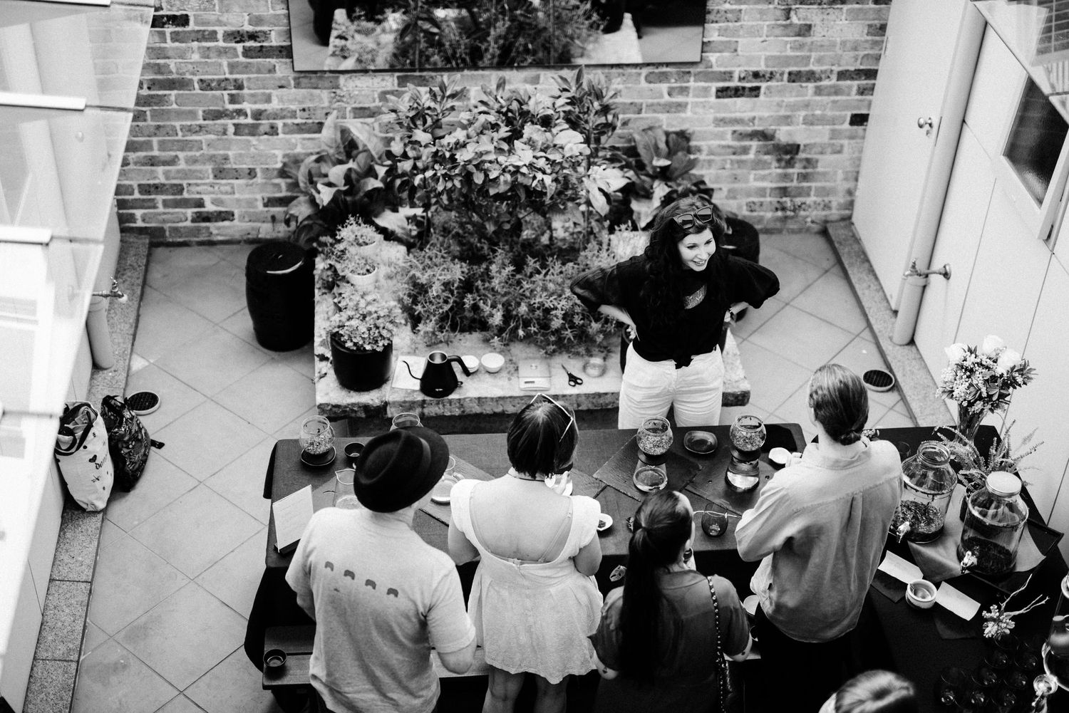 Black and white panorama of people gathered in front of a brick building.