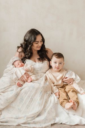 A series of intimate photos showing tender moments between parent and baby in soft white and beige tones against neutral backdrop.