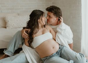 Intimate indoor maternity photo with couple in casual white and denim outfits at a studio in Huntington Beach