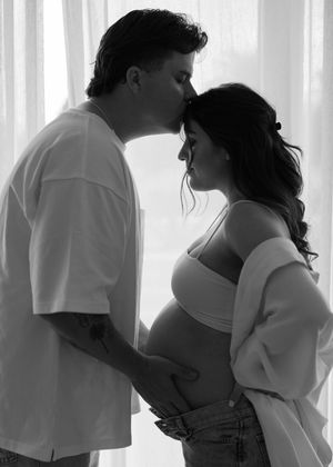 Dramatic black and white maternity photo of couple by window at a studio in Huntington Beach