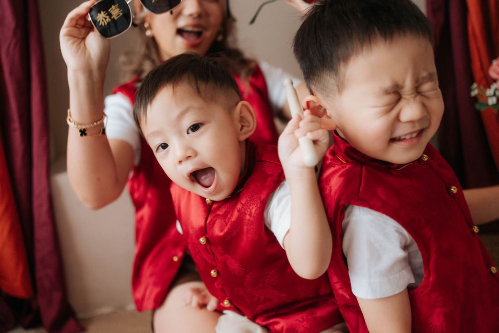Candid family moment showing playful expressions and emotions in red holiday attire.