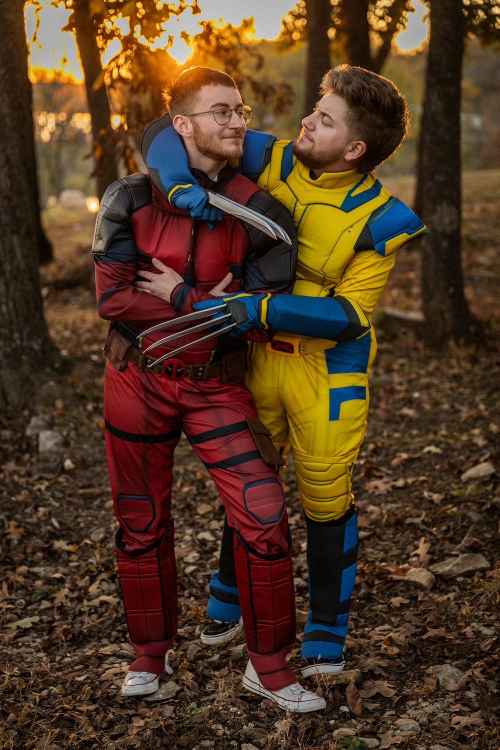 Two children in colorful jumpsuits play together in an autumn forest during golden hour sunset.