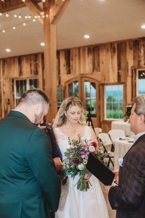 Wedding reception candid moments inside a rustic wooden barn venue with string lights.