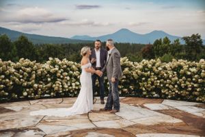 Scenic mountain wedding venue with stone patio and yellow rose garden.