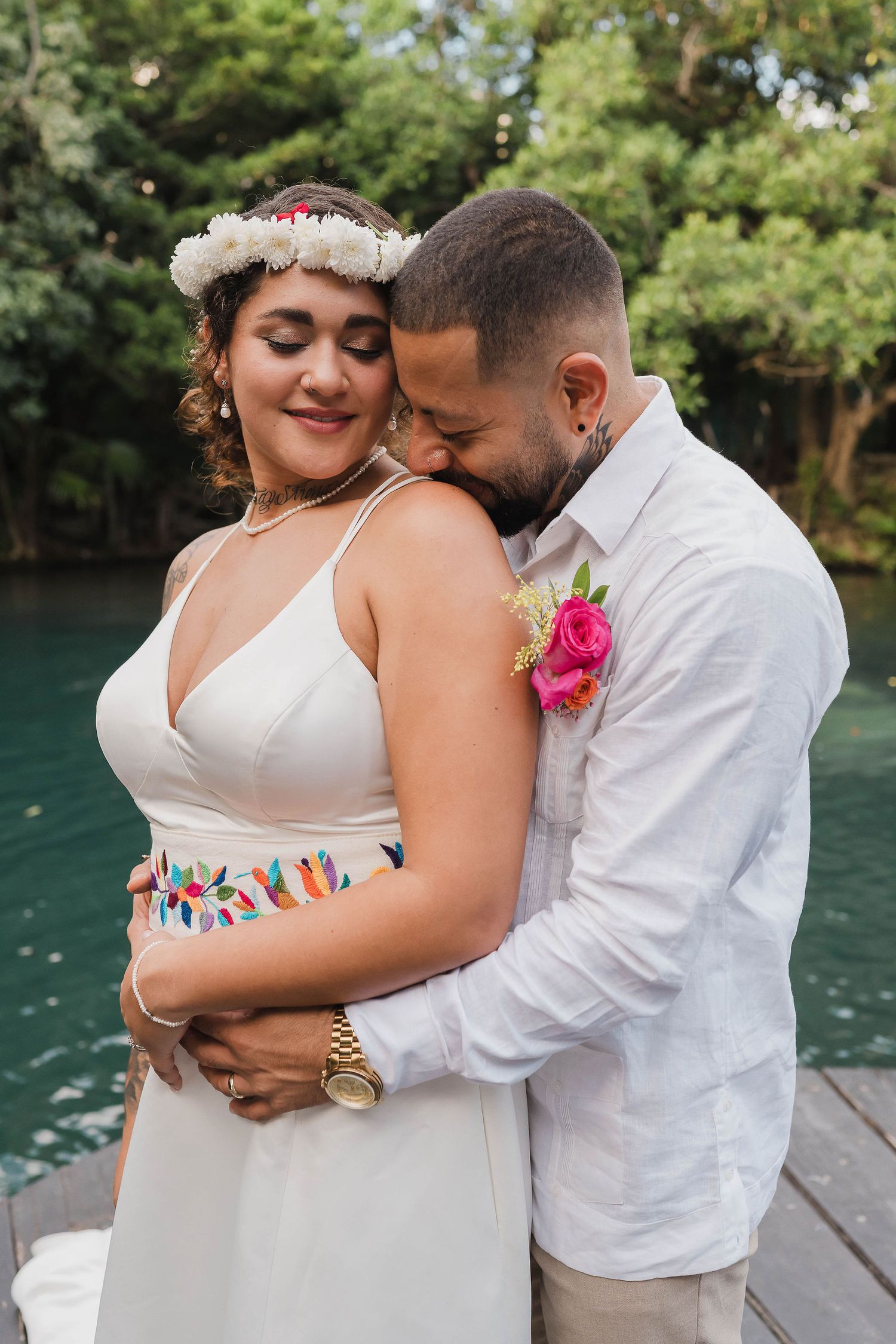 An intimate moment shared on a wooden deck overlooking turquoise waters, with tropical decorative details, Sandos Caracol Wedding.