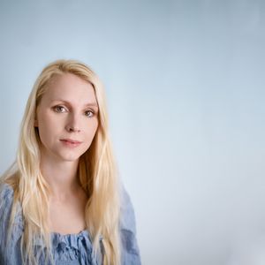 Mother during a family photoshoot near Hereford. The mum is in a blue top and the image has a blue background.