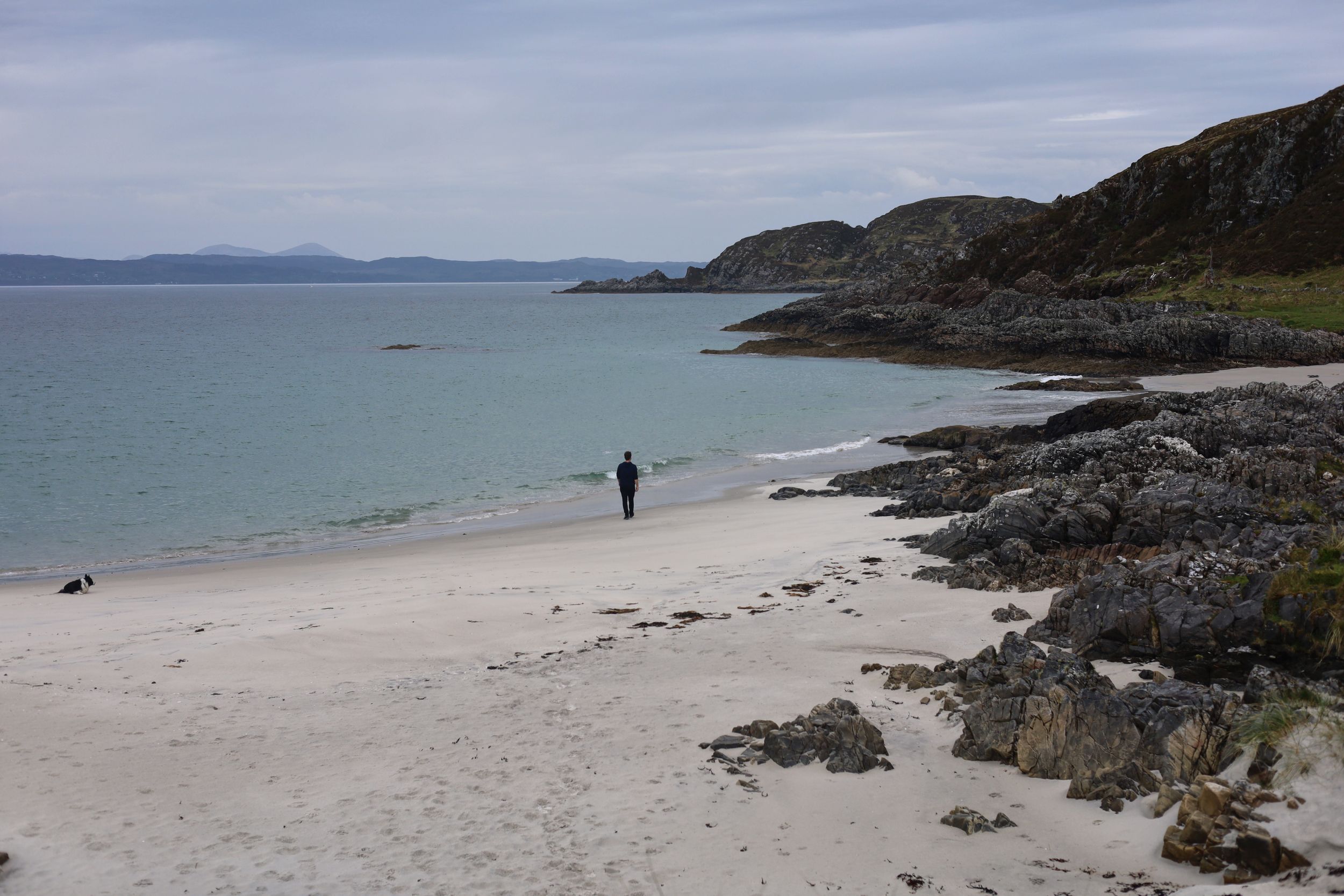 Scenic beach landscape with rocky outcrops and pristine white sand.