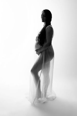 Black and white maternity photo of a pregnant woman in sheer fabric, Maternity Photographer in Cypress TX | Luxury Photography