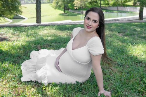 Outdoor pregnancy portrait surrounded by natural light and soft tones best Cypress TX photographer near me