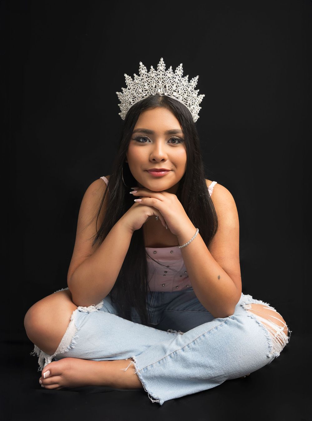 Portrait with ornate silver crown against black background.