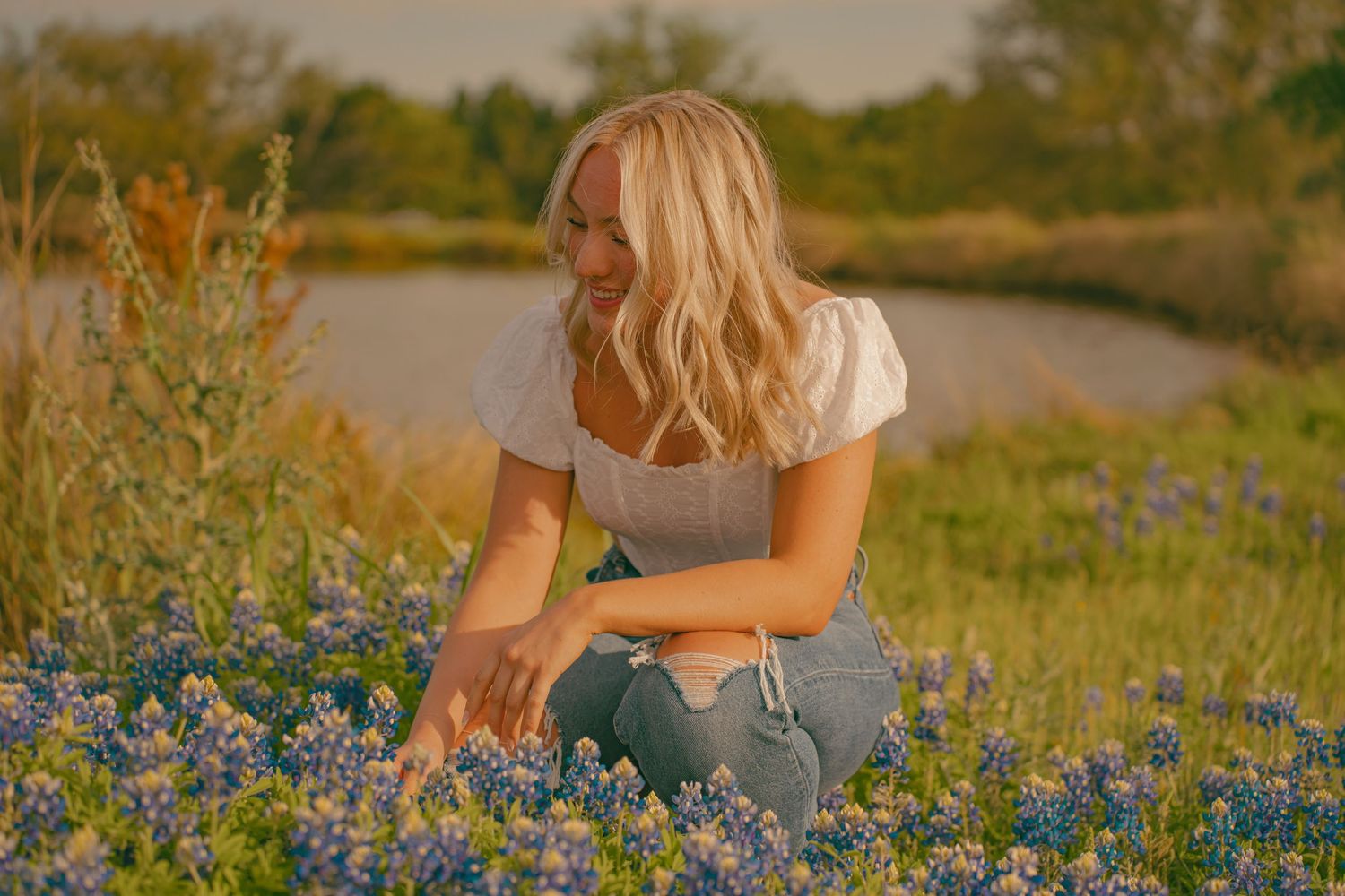 Person sitting among blooming bluebonnets in a spring meadow.