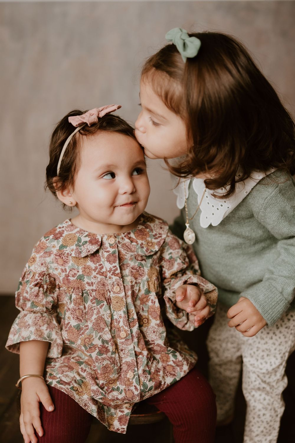 Sweet moment between two young siblings in vintage-inspired outfits.