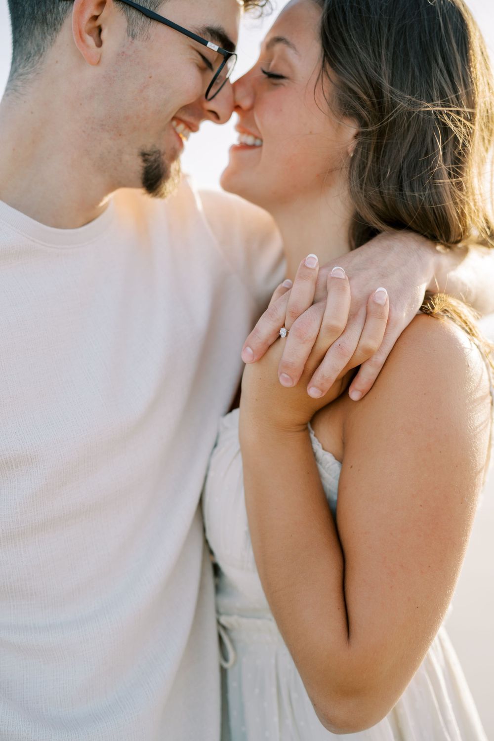 A tender close-up moment between a couple during a beach photoshoot.