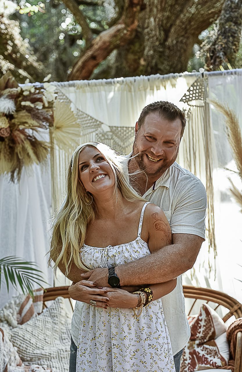 A romantic outdoor portrait against a macrame backdrop with natural garden elements.