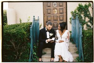 A romantic outdoor engagement photo session featuring a couple in white outfits posing in front of stone columns.
