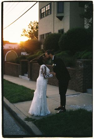 Romantic sunset silhouettes on a brick-lined pathway outside a building at dusk.
