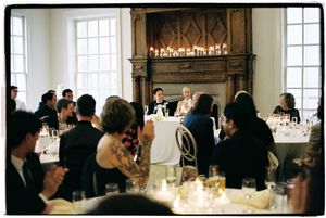 Panoramic view of guests mingling at an elegant reception in a bright room with large windows.